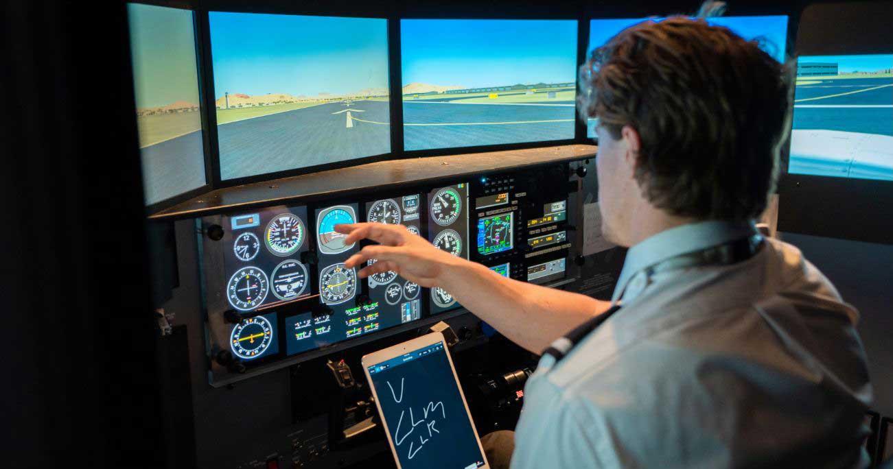 Pilot reading instruments on RedBird flight simulator