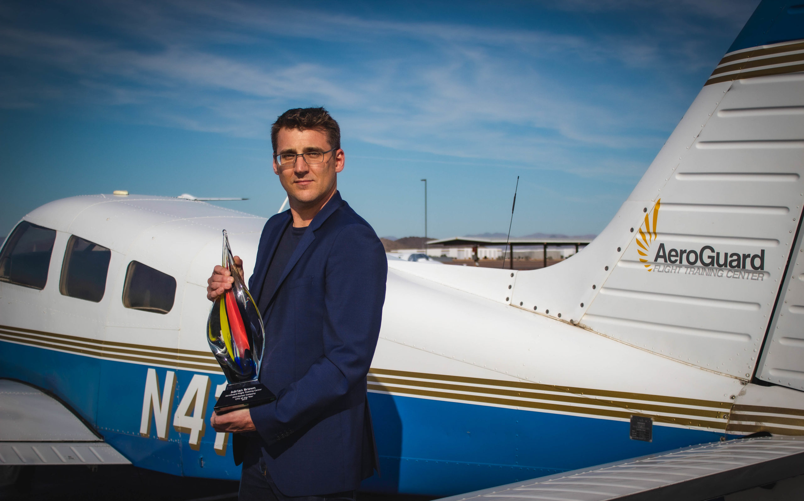 AeroGuard CFO holding award in front of plane